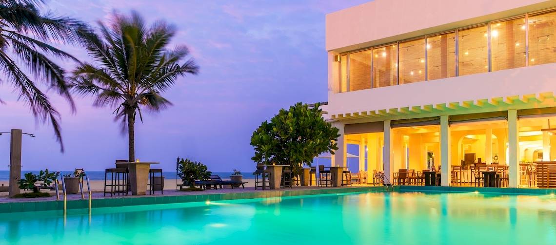Jetwing Sea Hotel Pool bei Nacht mit Palmen und Meer im Hintergrund