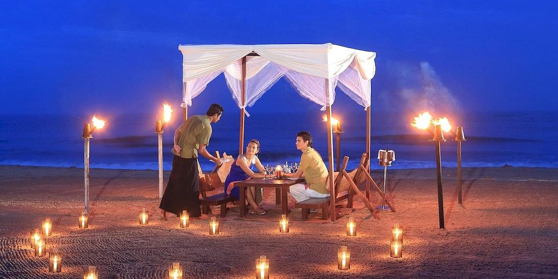 Ein Paar genießt ein romantisches Abendessen unter einem Zelt auf dem Strand des Jetwing Sea.