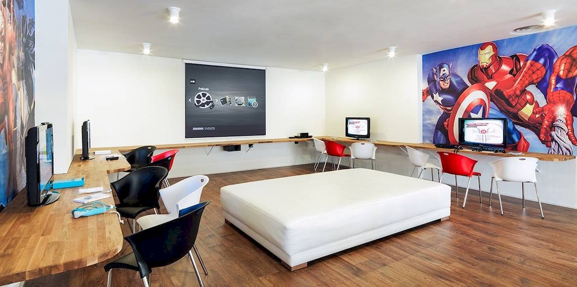Spielzimmer im H10 Conquistador Hotel mit Computern, Sofas und Comic-Wand