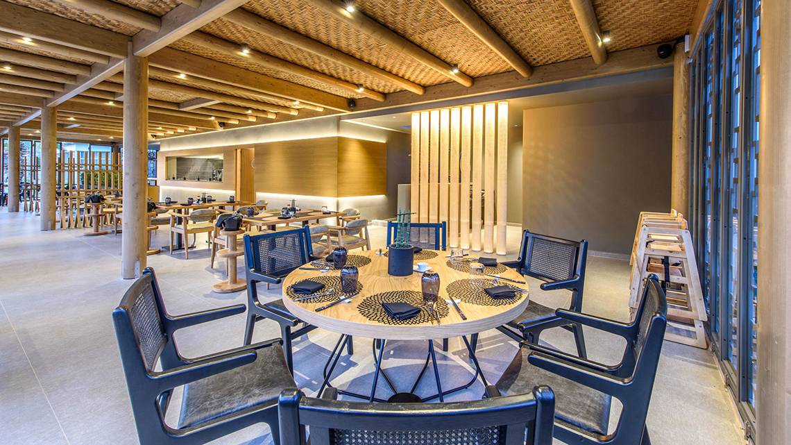 Innenbereich des Stella Palace Resort & Spa, modernes Restaurant mit Holzelementen und Glasfenstern.