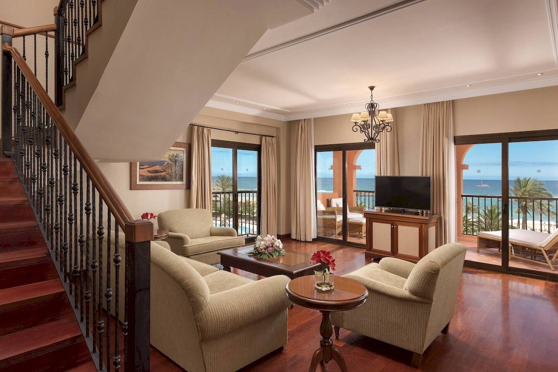 Innenansicht eines Strandhotels mit Wohnzimmer und Meerblick