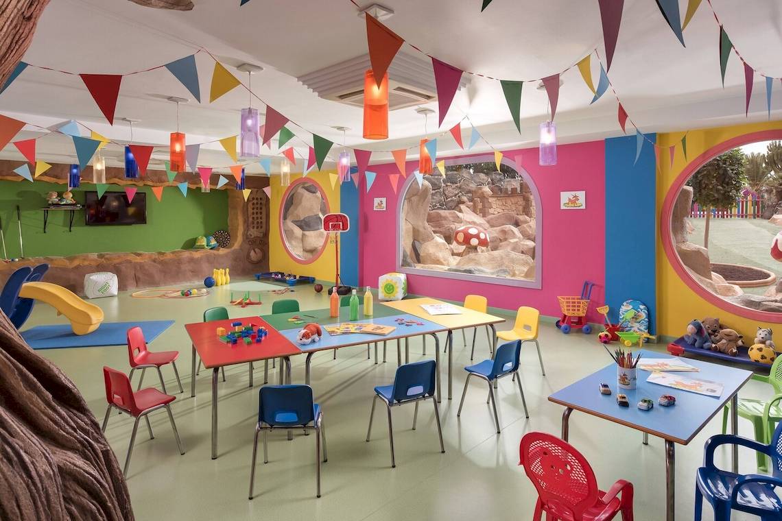 Kinderzimmer im Sheraton Fuerteventura Beach, Golf & Spa Resort mit bunten Wänden, bunten Tischen und Stühlen.
