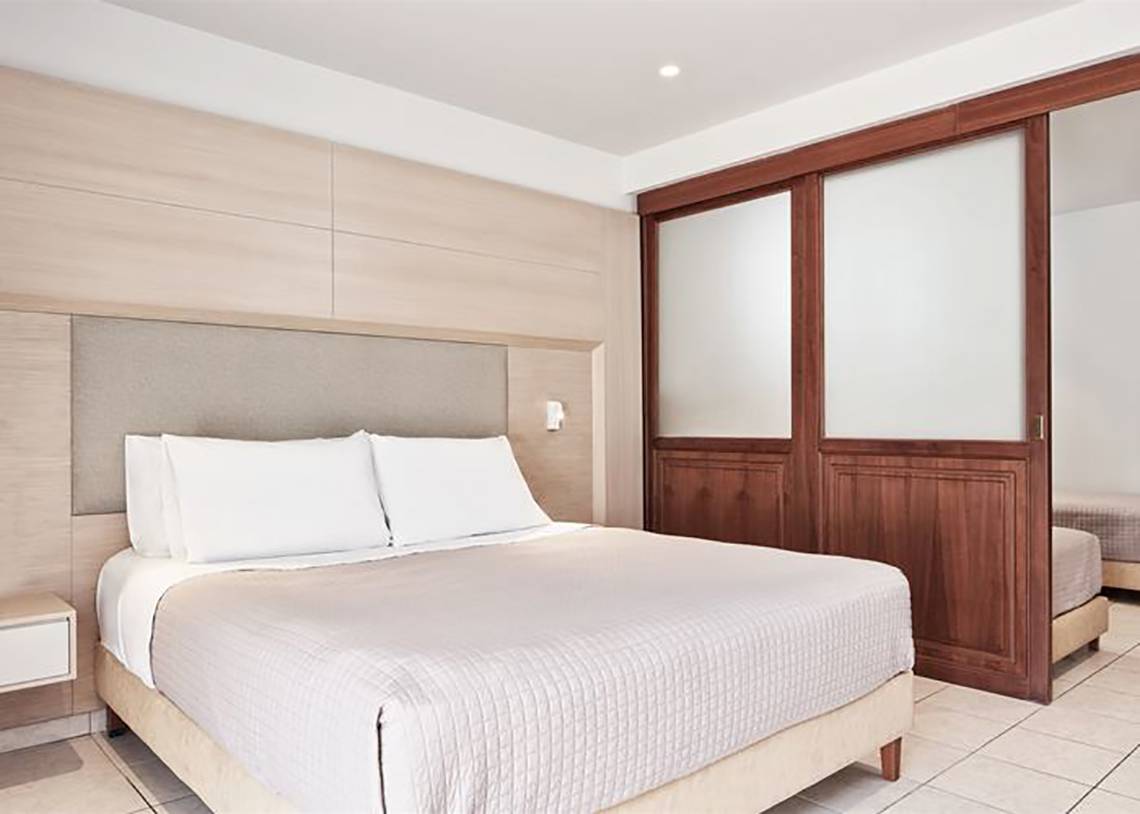 Schlafzimmer im Porto Bello Royal Hotel mit Bett, Kissen und Holzschrank