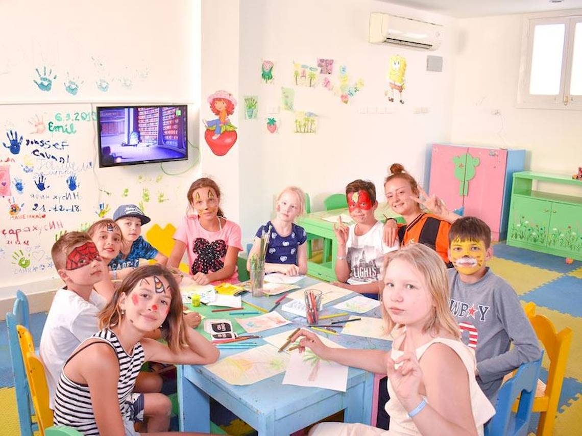 Gruppe von Kindern im Parrotel Beach Resort Spielzimmer mit Gesichtern bemalt und um einen Tisch versammelt