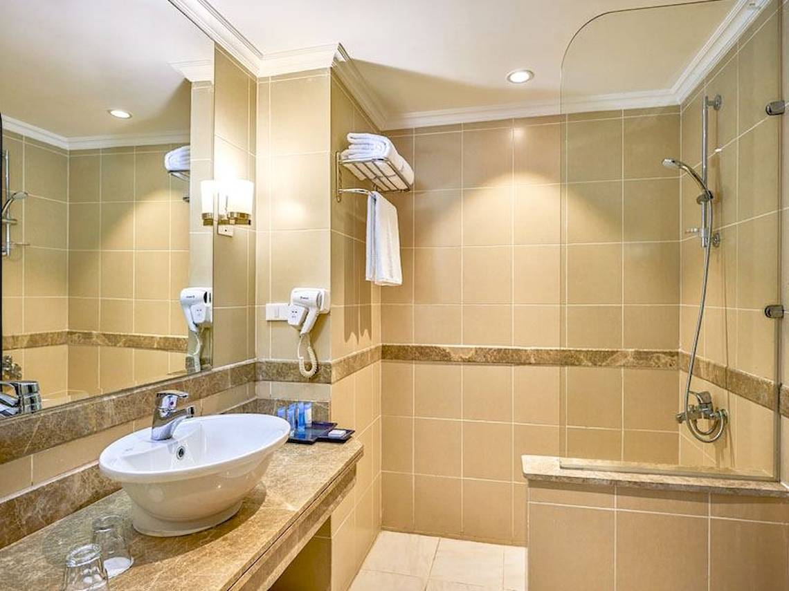 Badezimmer im Parrotel Beach Resort mit Badewanne, Dusche, Waschbecken und Spiegel