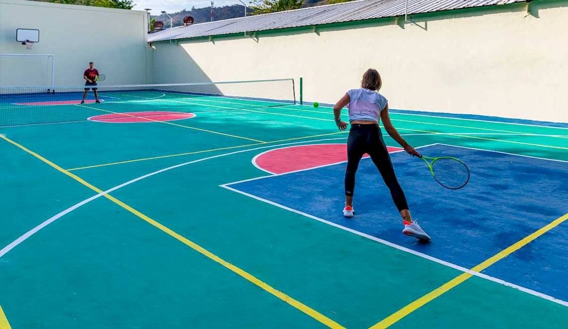 Tennisplatz im Playabachata Spa Resort Hotel mit zwei Spielern, die Tennis spielen.