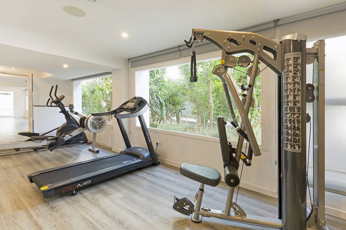 Fitnesscenter im HSM Golden Playa Hotel mit Geräten und Blick auf Bäume