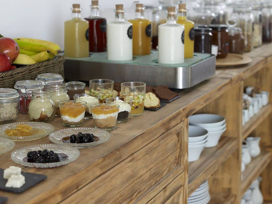 Frühstücksbuffet im Rocabella Mykonos Art Hotel & Spa mit verschiedenen Desserts, Früchten und Getränken.
