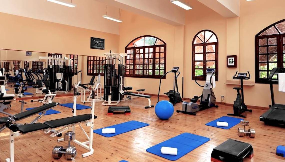 Fitness Center im Jaz Makadi Oasis Resort & Club mit Geräten und Yoga-Matten auf Holzboden.
