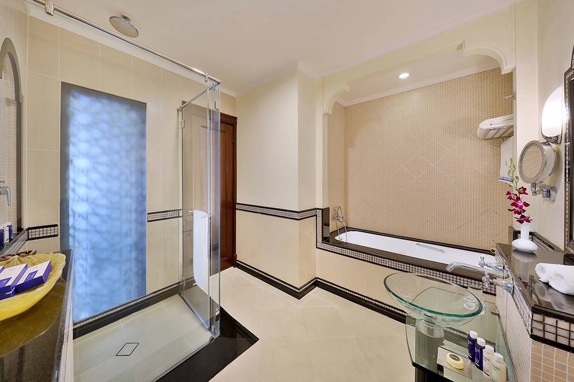 Eleganter Badezimmerbereich im Habtoor Grand Resort & Spa mit Badewanne und separater Dusche.