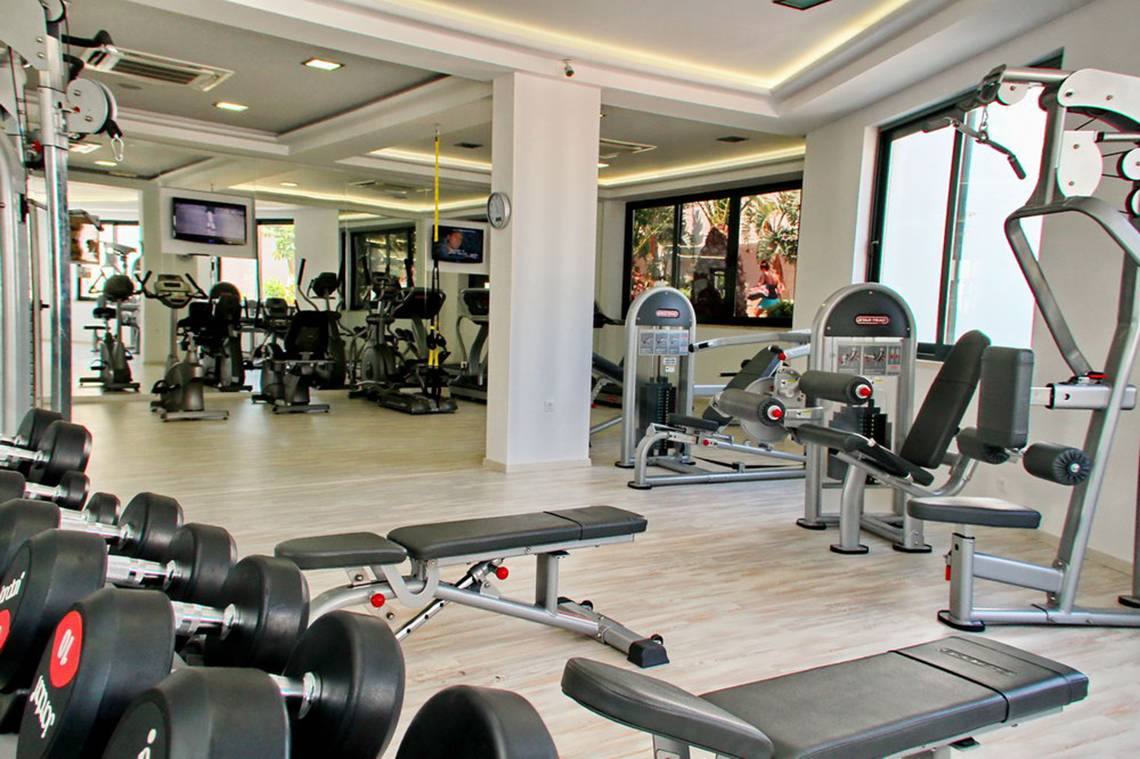 Fitness-Center im Nana Golden Beach Hotel mit verschiedenen Trainingsgeräten und Gewichten.