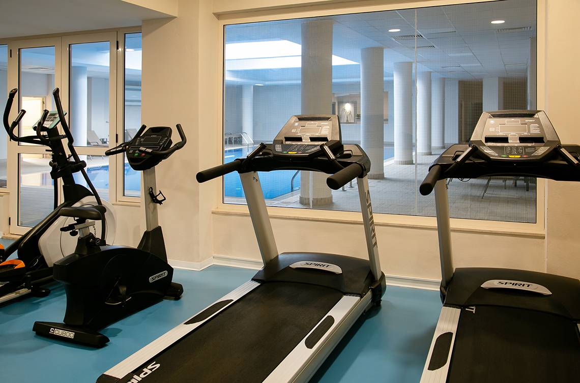 Fitnessgeräte im Louis Paphos Breeze Hotel mit Blick auf den Pool.