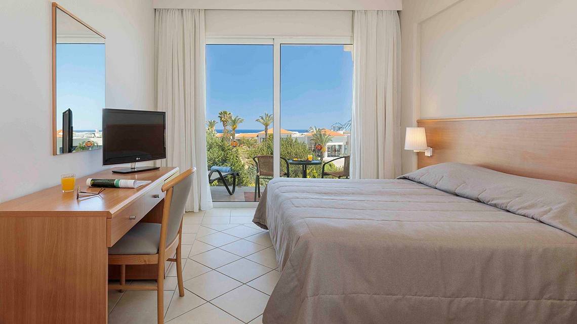 Zimmer im Rodos Princess Beach Hotel mit Blick auf den Balkon und das Meer.