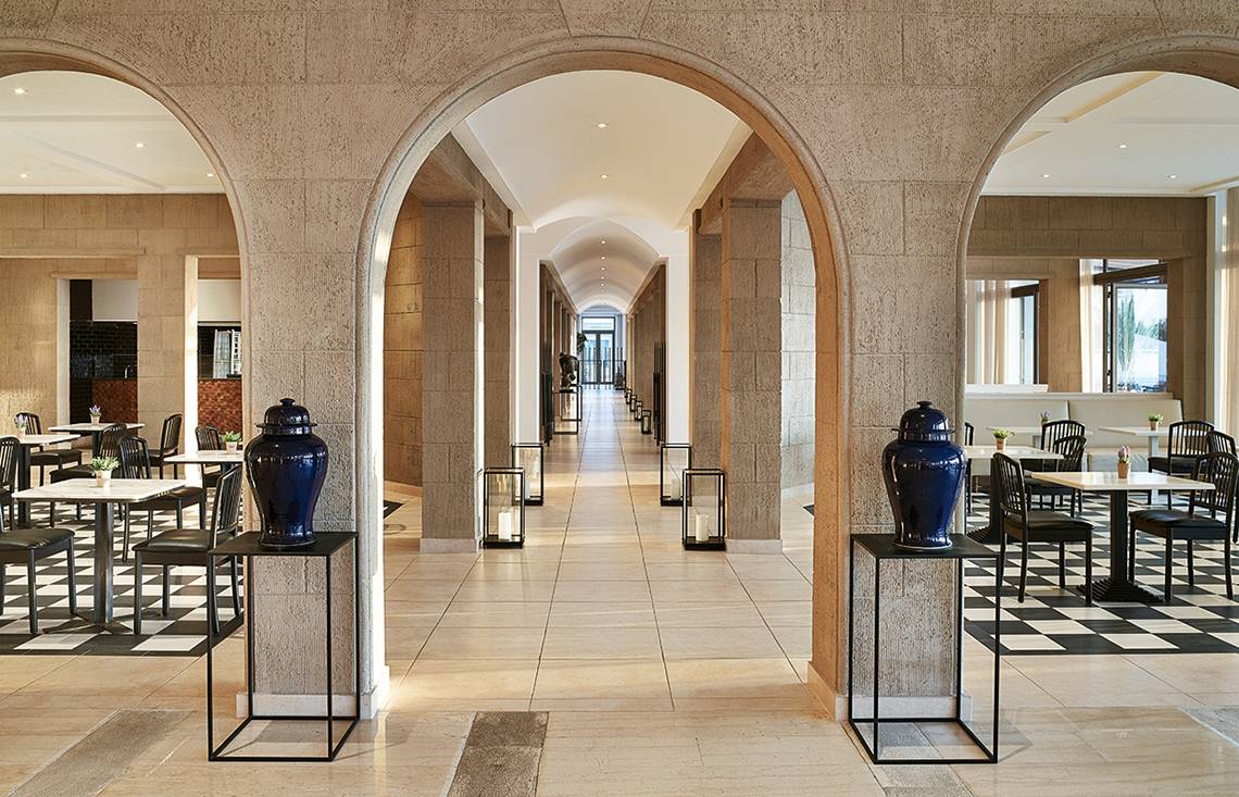 Innenansicht des Grecotel Lux Me Dama Dama Restaurants mit blauen Vasen und gemusterten Böden.