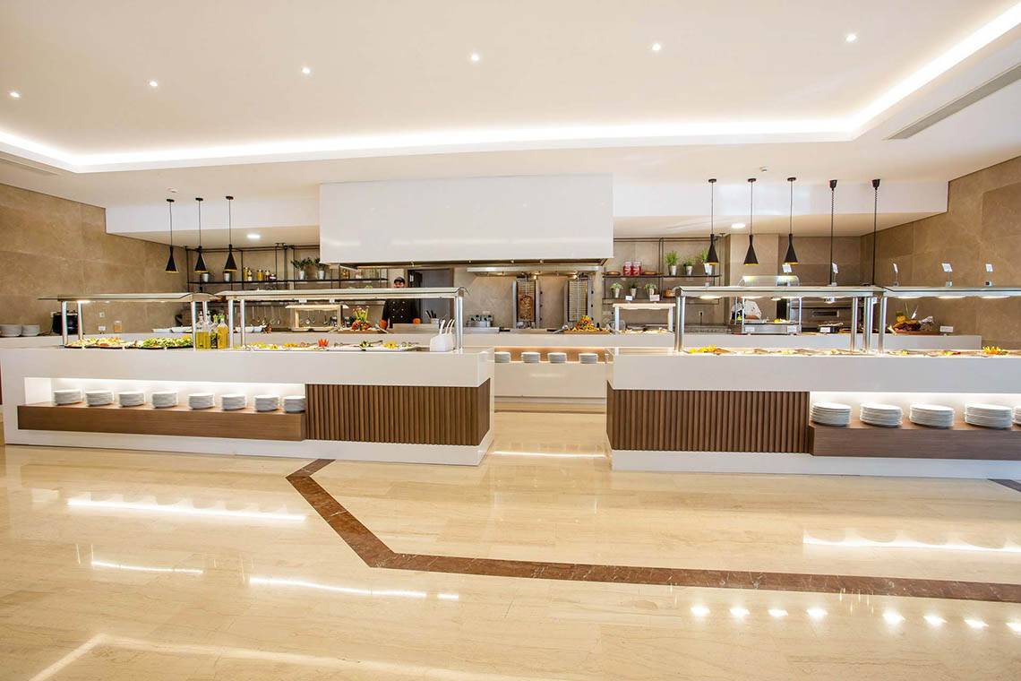 Buffetbereich des Niriides Beach Hotels mit weißen Platten und Speisen in Vitrine