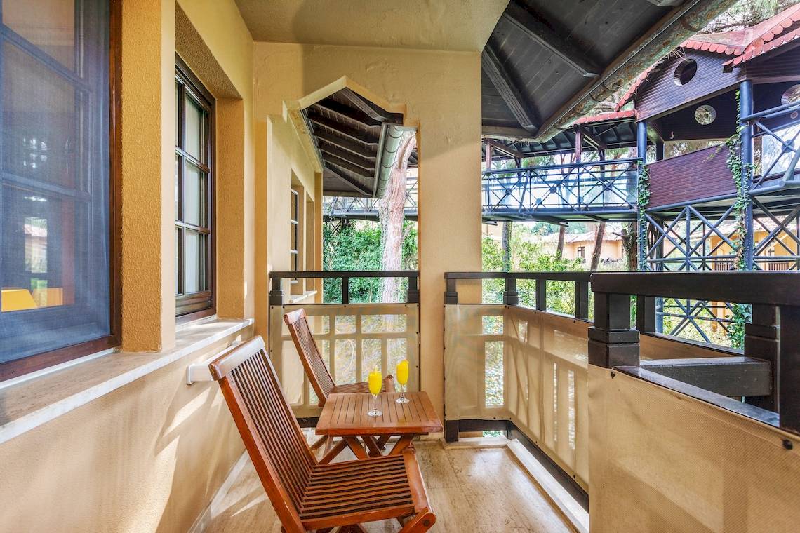 Balkon im Asteria Family Resort Belek mit zwei Holzstühlen und einem Tisch draußen