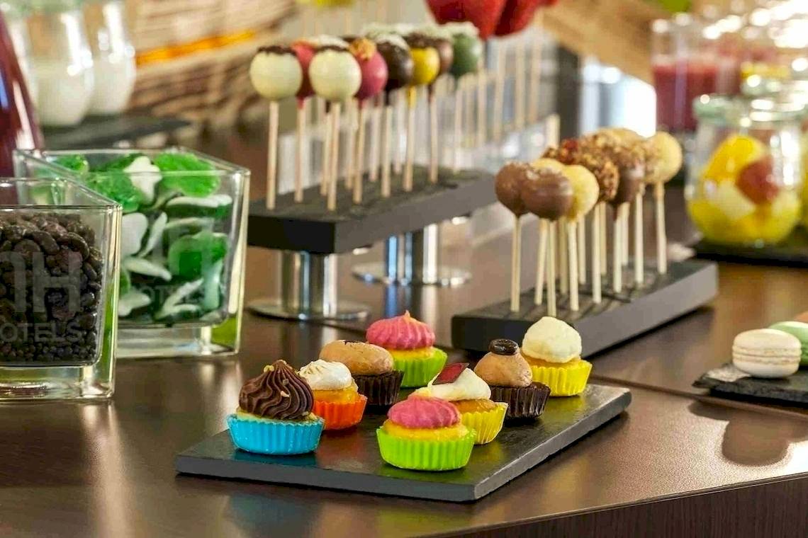 Buffet mit verschiedenen Süßigkeiten wie Cupcakes und Macarons im NH Hamburg Altona.