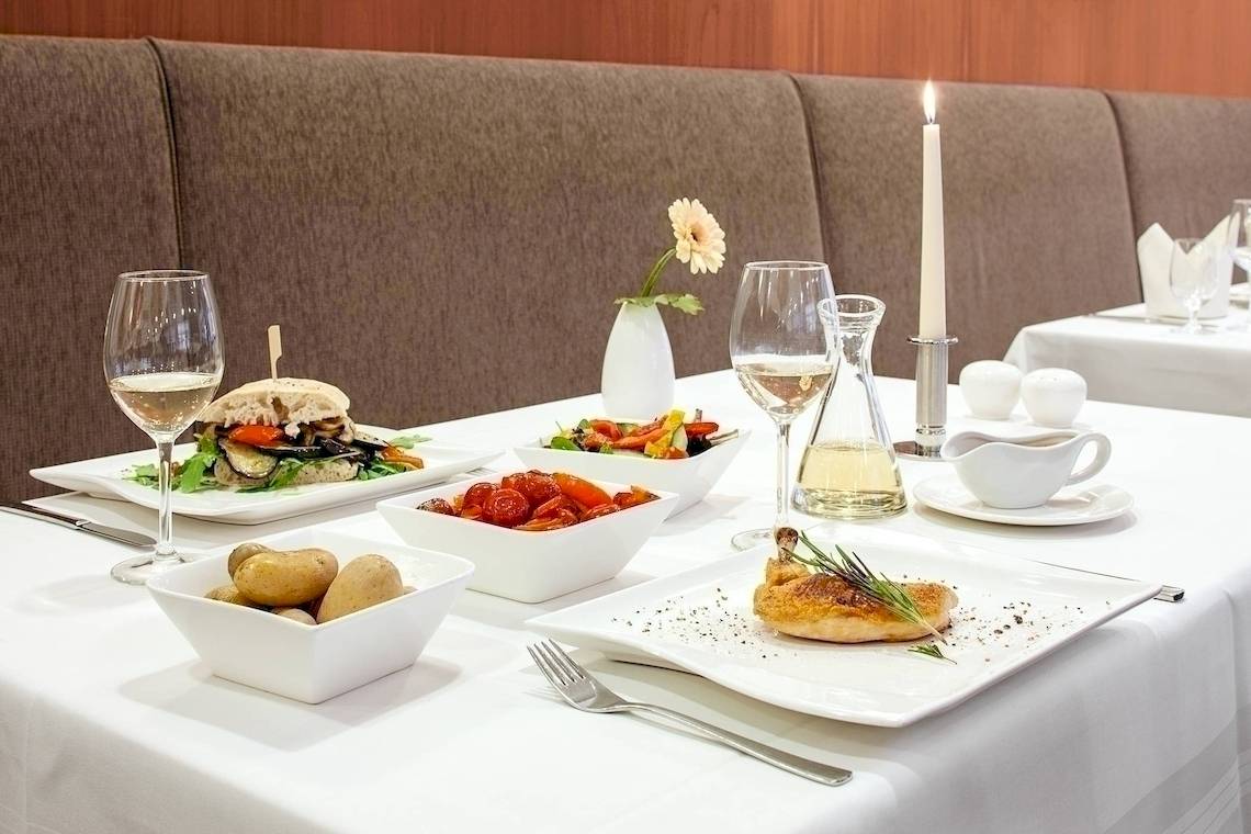 NH Hamburg Altona Essen am Tisch mit verschiedenen Gerichten und Getränken.