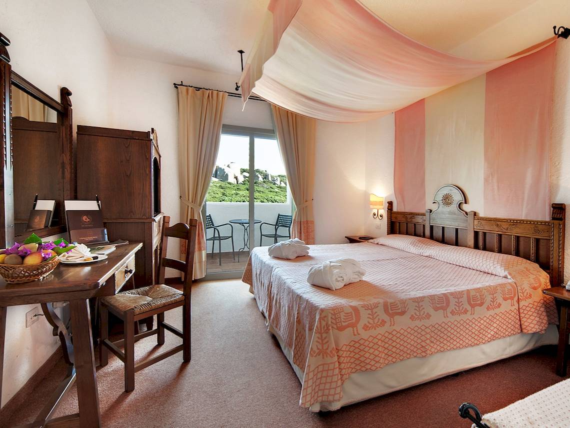 Doppelzimmer im Colonna Grand Hotel Capo Testa mit zwei Betten und Balkon.