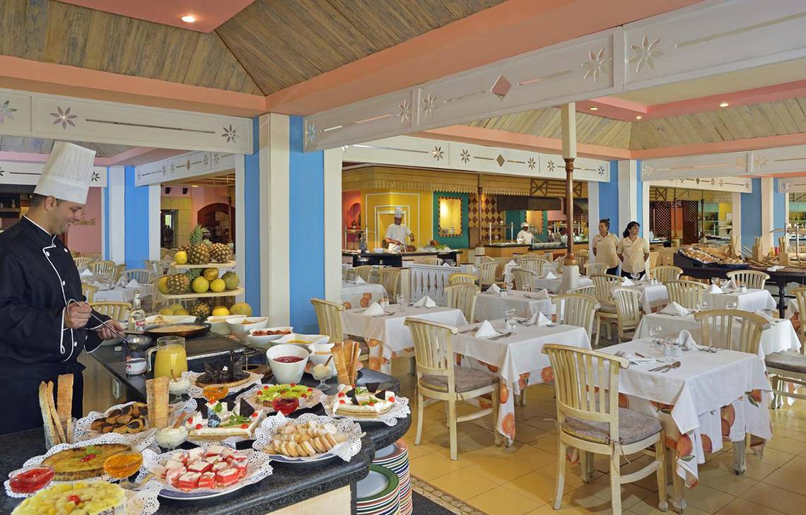 Frühstücksbuffet im Sol Palmeras Hotel mit einem Koch, der Gerichte zubereitet.
