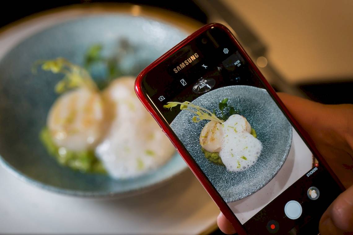 Ein Smartphone fotografiert ein Gericht im Gran Hotel Havana Barcelona.