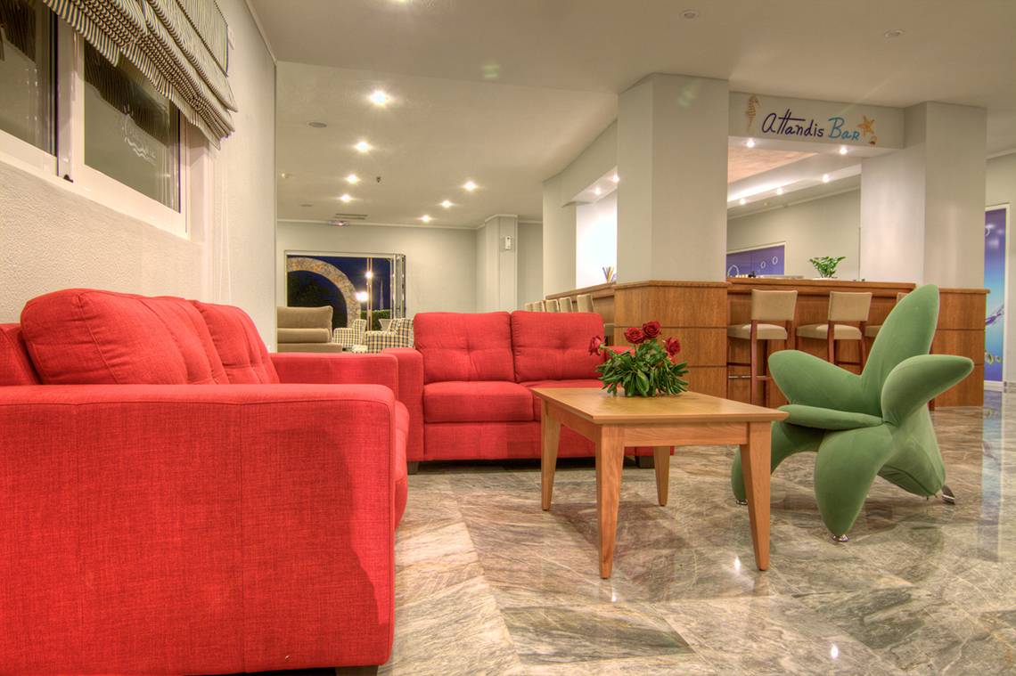 Hotellobby mit roten Sofas, Tisch und grünem Stuhl im Solimar Dias Hotel.