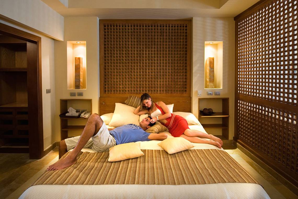 Paar entspannt sich im Hotelbett im Grand Waterworld Makadi