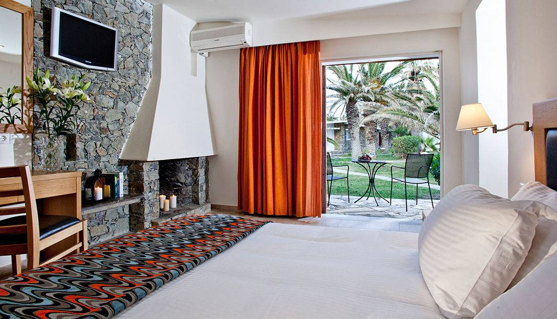 Hotelzimmer im Civitel Creta Beach mit Bett, Kamin, Fernseher und Terrassenblick.