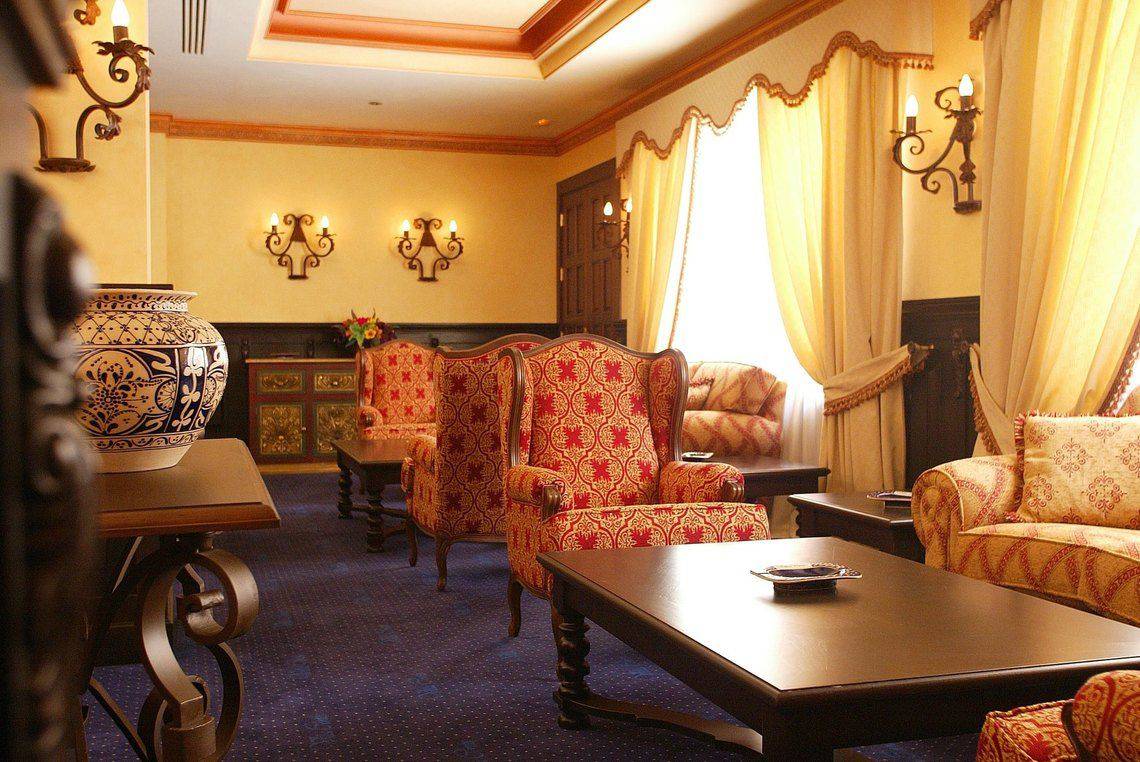 Hotellobby der Europe Villa Cortes mit dekorativ eingerichteten Sitzbereichen, Vasen und Wandleuchten.