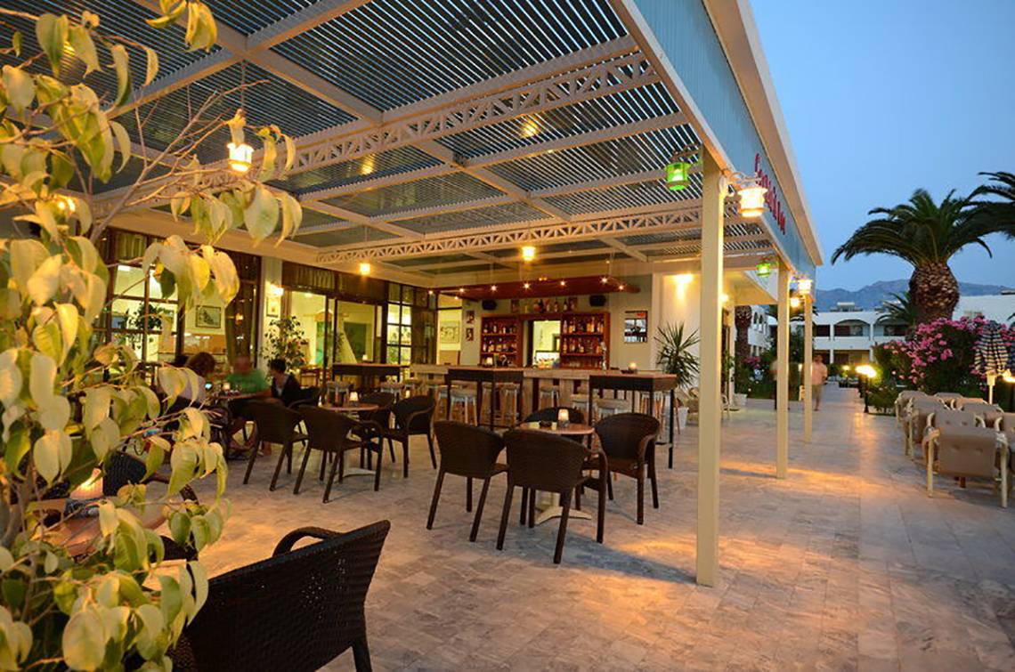 Abendliche Außenterrasse des Tropical Sol Hotels mit beleuchteten Tischen und Stühlen.