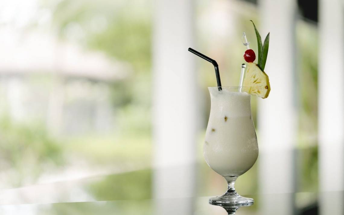 Cocktailglas mit Strohhalm und Ananasdekoration im Noku Maldives Hotel.