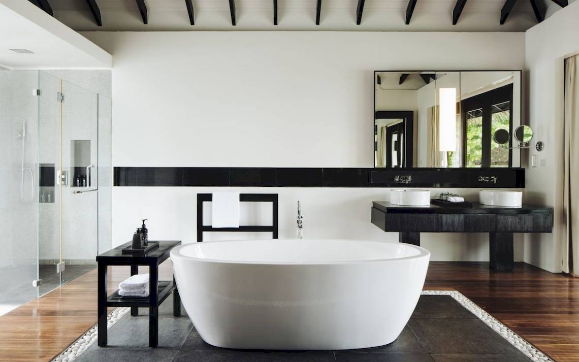 Luxus Badezimmer im Noku Maldives mit Badewanne, Waschbecken und Glasdusche