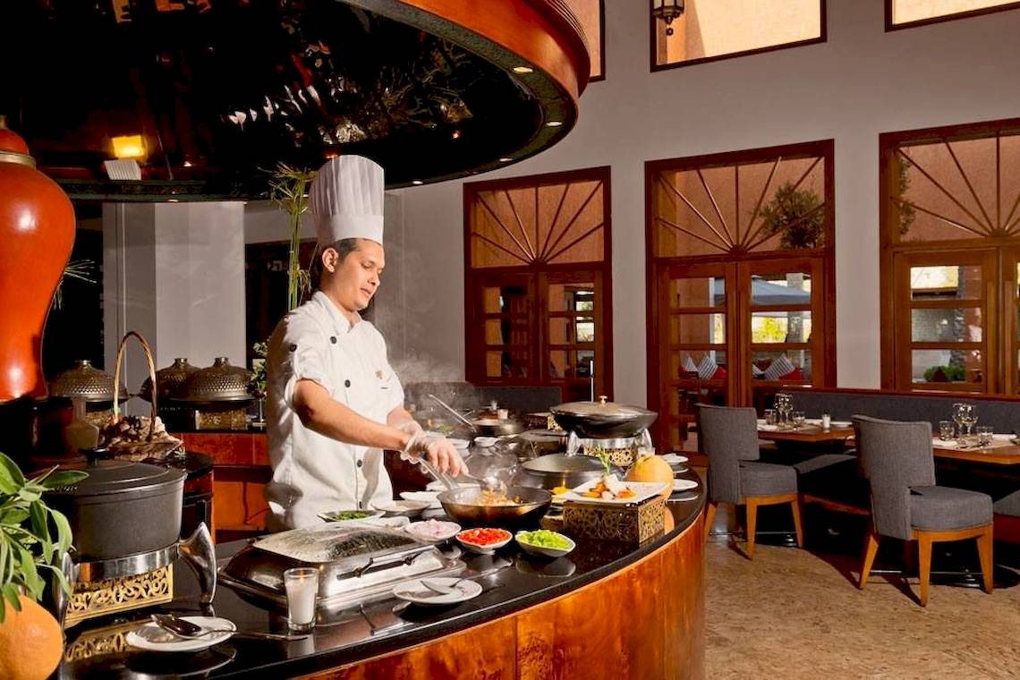 Koch im Restaurant des Sofitel Agadir Royal Bay Resort, der Speisen zubereitet.