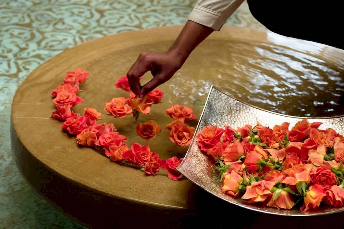 Eine Person, die Rosen in einem Wasserbecken im Sofitel Agadir Royal Bay Resort arrangiert.