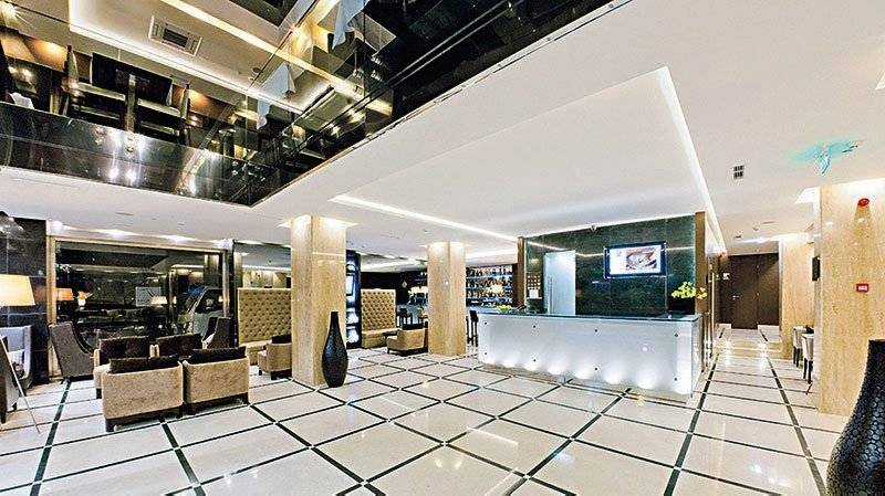 Empfangshalle des Turim AV Liberdade Hotels mit weißer und schwarzer Marmorfliesenboden und moderner Einrichtung.