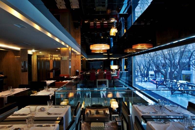 Innenansicht des Restaurants im Turim AV Liberdade Hotel mit Glaswänden und Blick auf die Außenwelt.