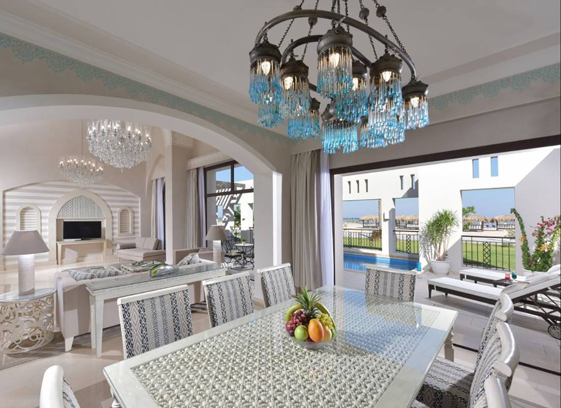 Suite im Steigenberger Alcazar mit Esstisch, Früchten, Kristallleuchtern und Blick auf den Pool.