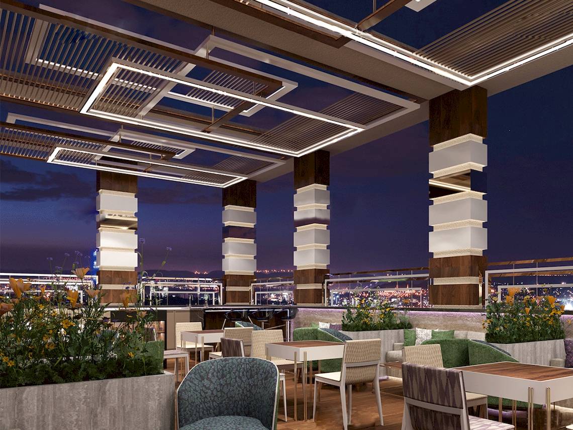 Abendbeleuchtung der Dachterrasse im Belad Bont Resort mit Tischen, Stühlen und Pflanzen