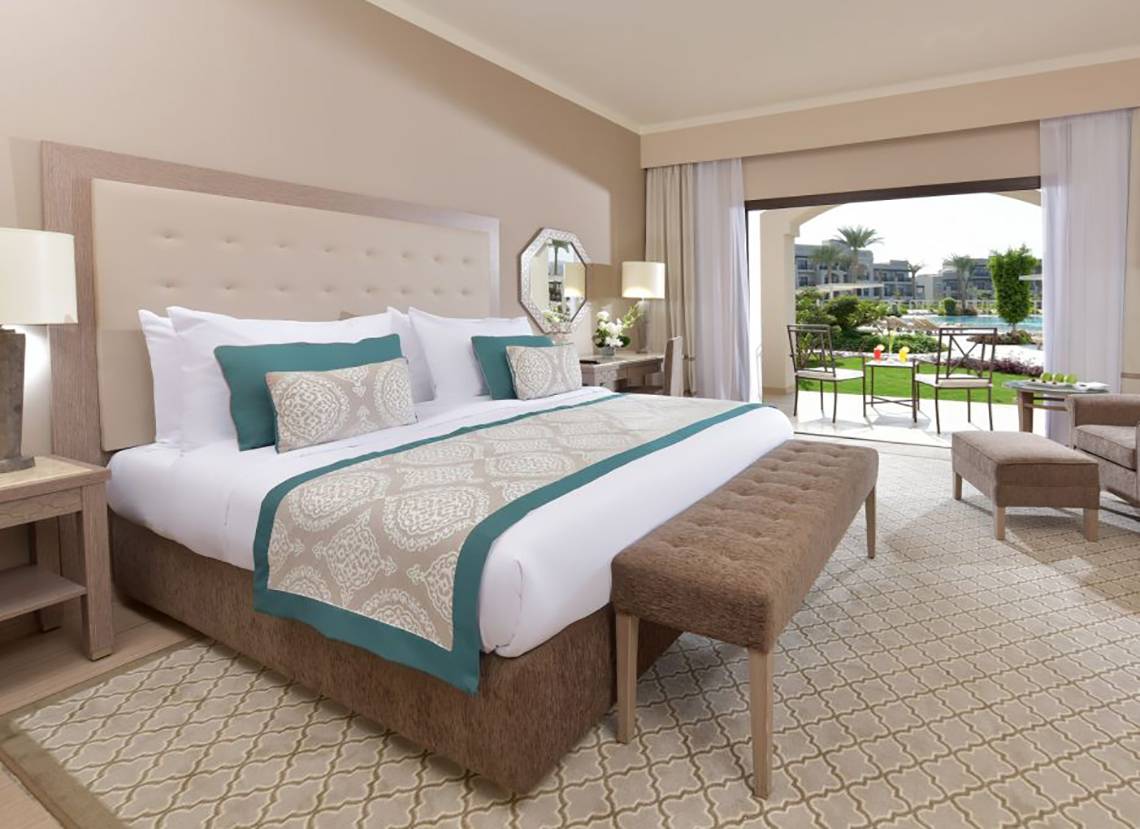 Hotelzimmer im Steigenberger Alcazar mit gepolstertem Kopfteil, großen Bett und offenem Balkon.