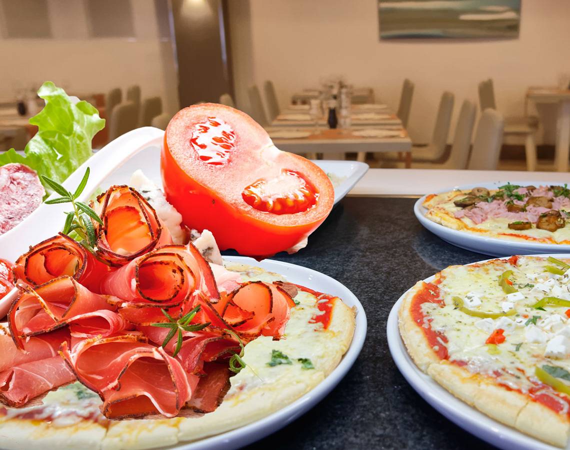 Servatur Waikiki Hotel Speisen auf einem Tisch mit verschiedenen Pizzen und Beilagen.