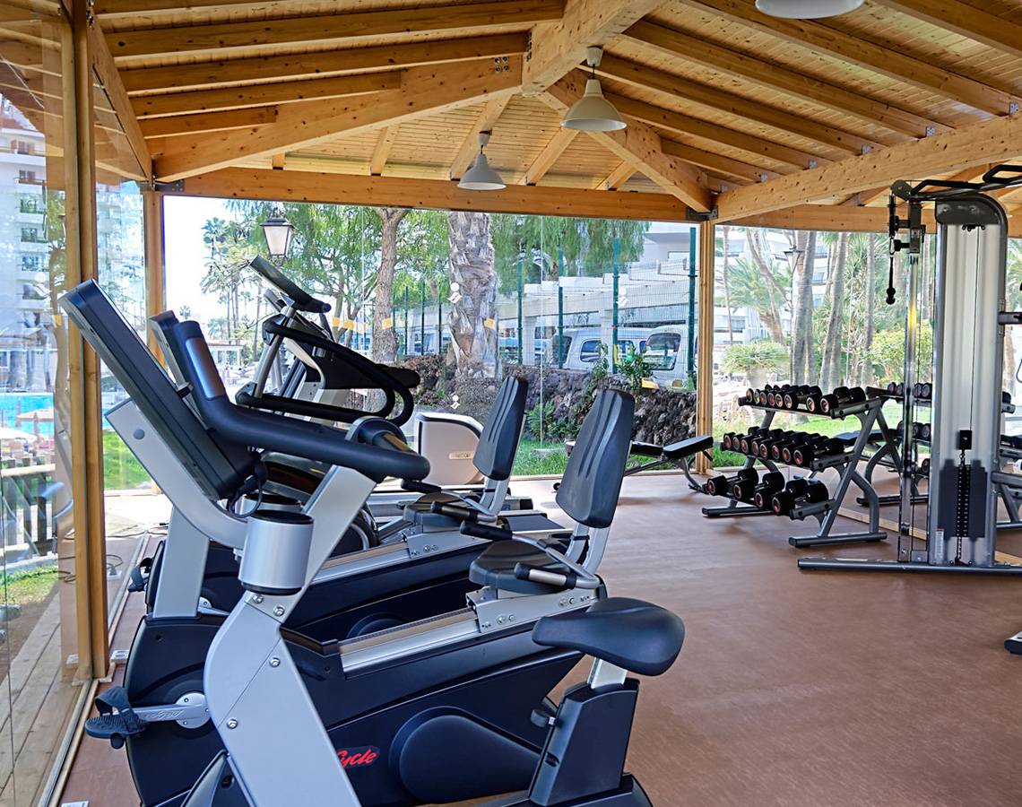 Fitnessstudio im Servatur Waikiki Hotel mit Cardiogeräten und Hanteln.