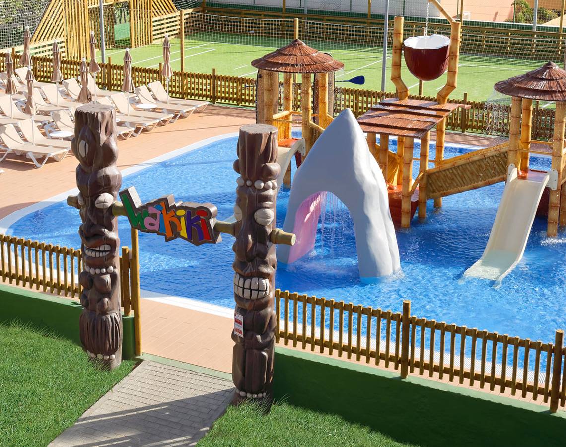 Außenansicht des Wasserparks im Servatur Waikiki Hotel mit Rutschen und Wasserspielgeräten.