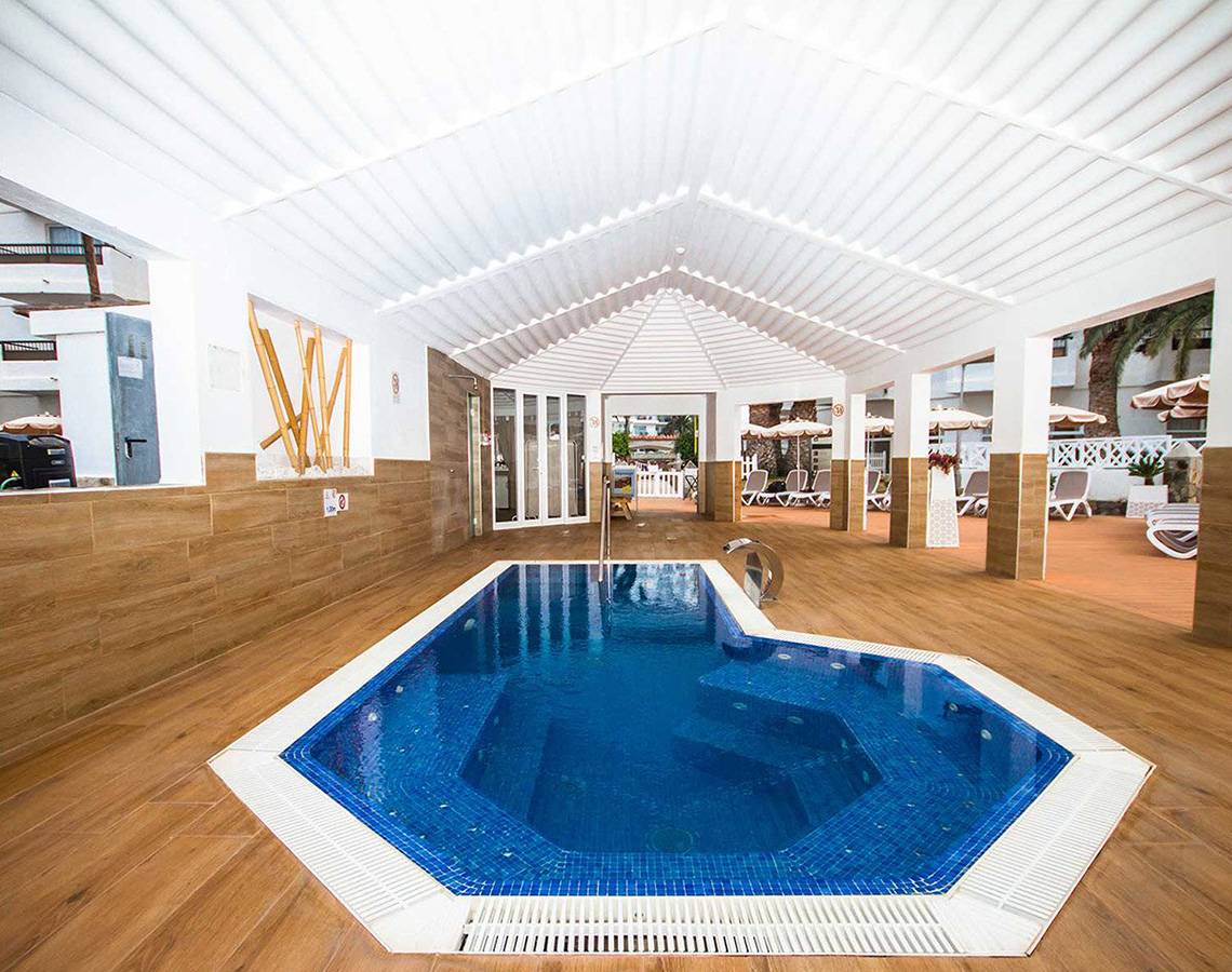 Innenpool des Servatur Waikiki Hotels mit modernem Design und blauem Wasser.