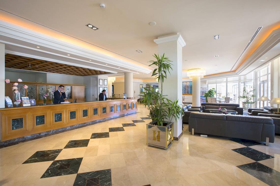 Empfangsbereich des Hipotels Hipocampo Playa Hotel mit Rezeption und Sofas.