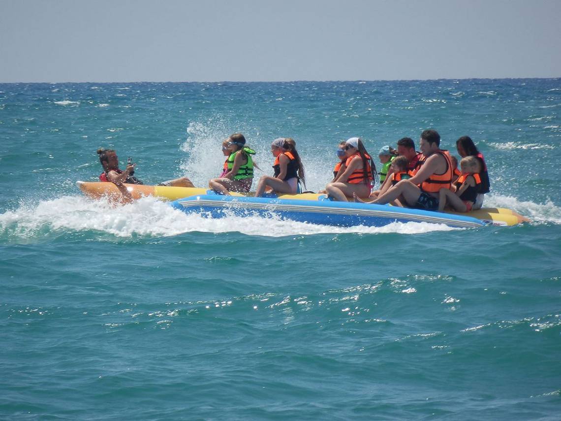 Gruppe von Leuten auf einem Boot im Meer, alle tragen orange Westen