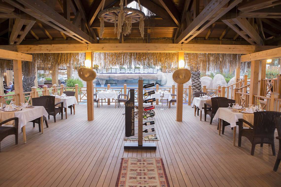 Innenbereich des Restaurants im Fame Residence Lara & Spa Hotel mit hölzernem Boden und Möbeln.