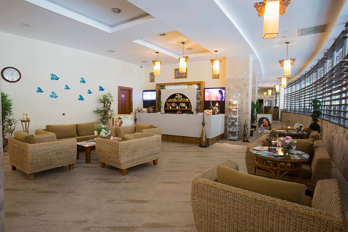 Lobby des Fame Residence Lara & Spa Hotels mit Sofas, Tischen und dekorativen Elementen.