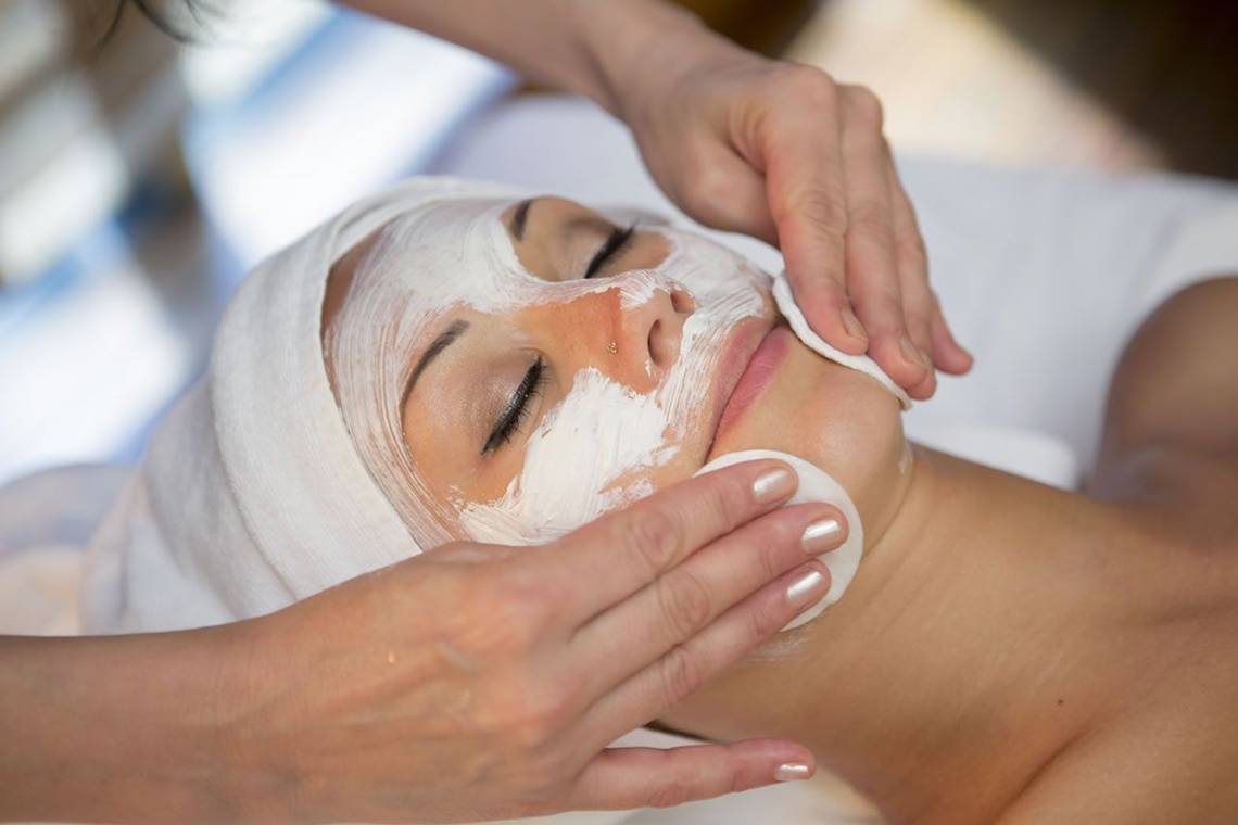 Frau im Fame Residence Lara & Spa Hotel mit einer weißen Gesichtsmaske