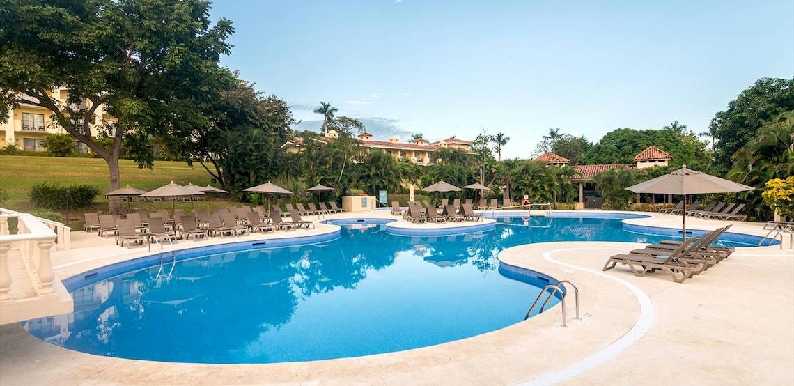 Außenpool des Occidental Papagayo Hotels mit vielen Liegestühlen und Sonnenschirmen