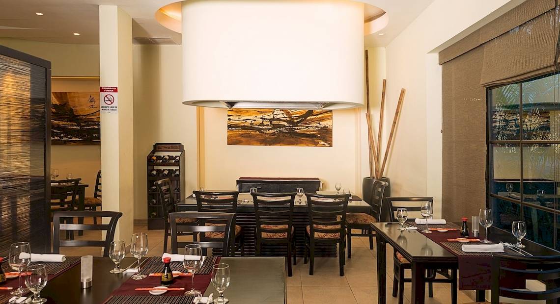 Innenansicht des Restaurants im Occidental Papagayo Hotel mit geräumigen Tischen, Stühlen und einem großen Kronleuchter.